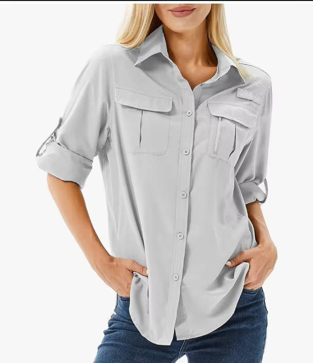 Woman wearing a light gray button-up shirt with rolled-up sleeves on a white background