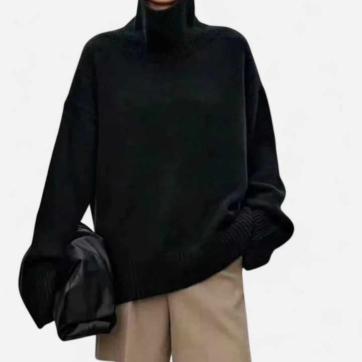 Person wearing a black turtleneck sweater with a plain background