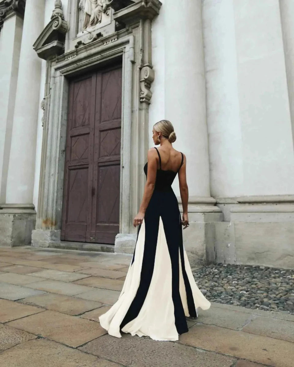 Woman in a black and white dress standing in front of a classical building.