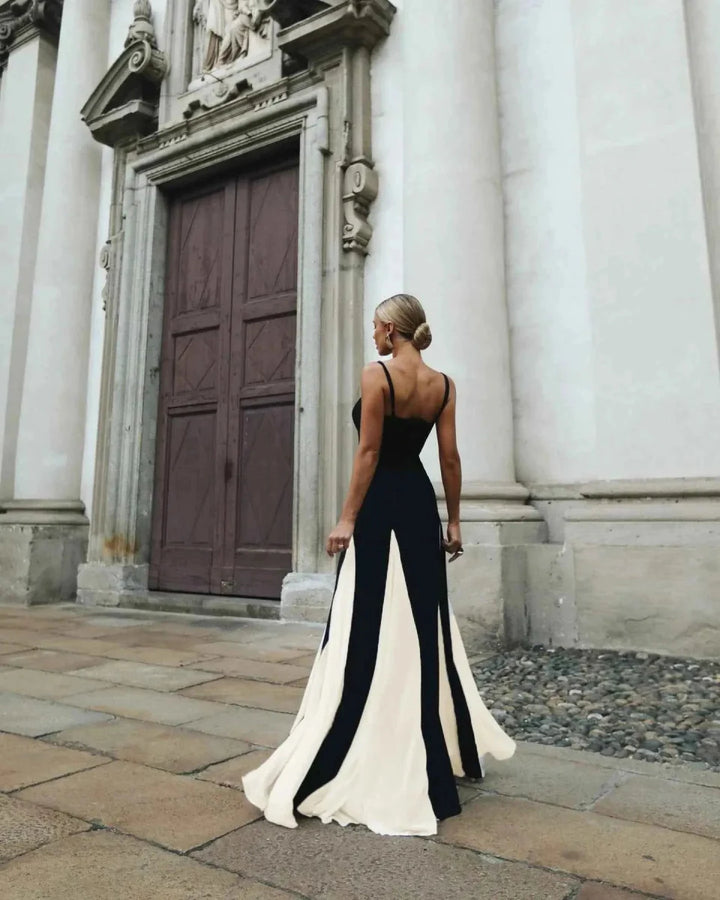 Woman in a black and white dress standing in front of a classical building.