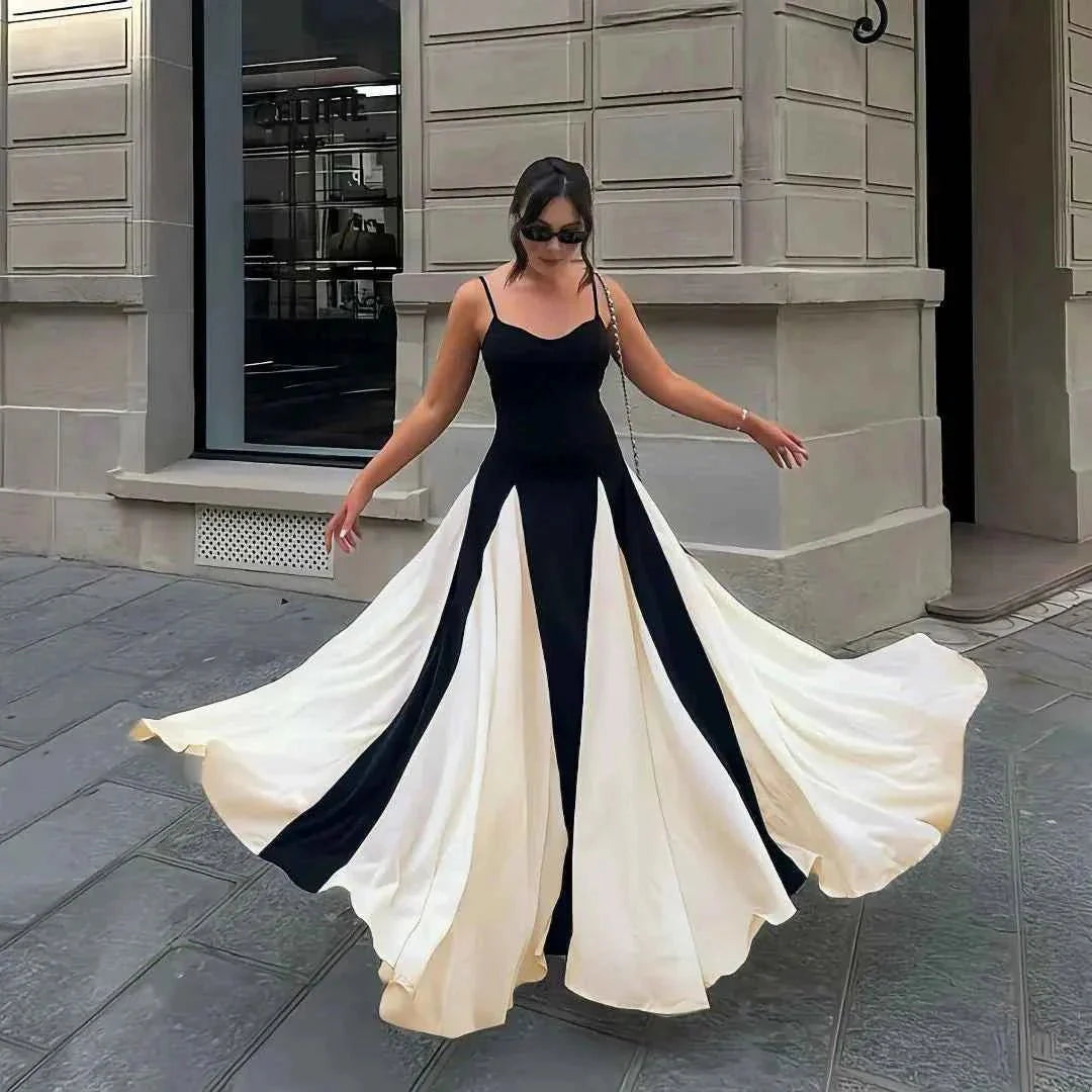 Woman in a black and white dress standing on a street.