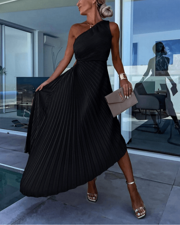 Woman in a black one-shoulder dress standing by a poolside.