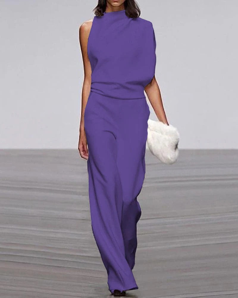 Purple jumpsuit worn by a model on a plain background