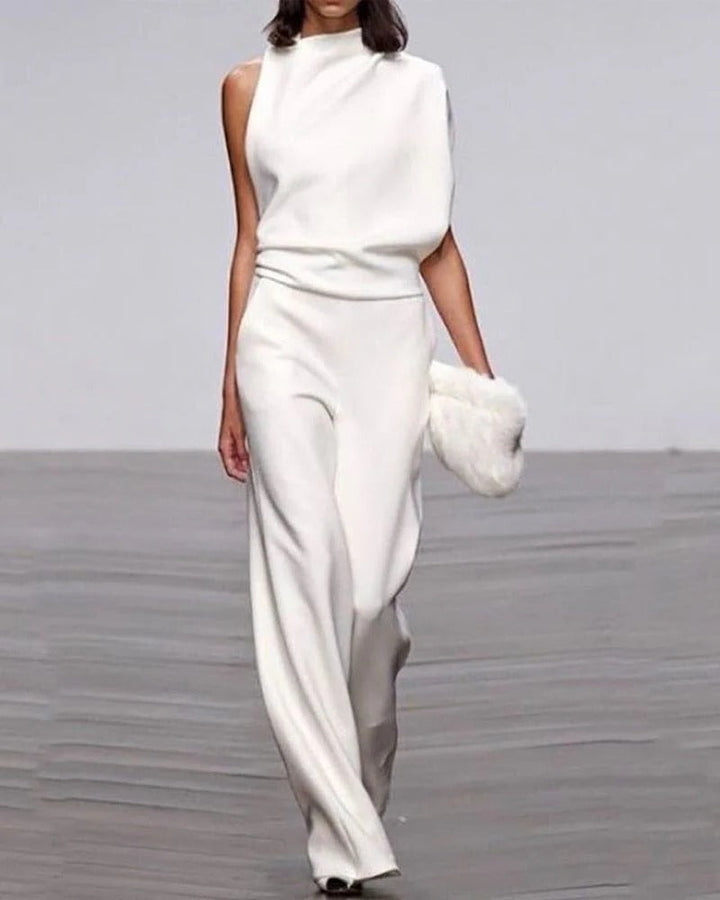 Person wearing a white outfit with wide-leg pants on a plain background