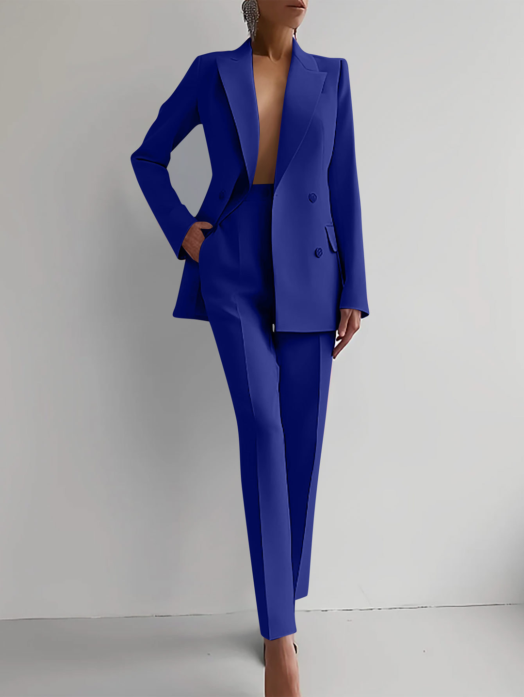 Person wearing a blue suit against a plain background