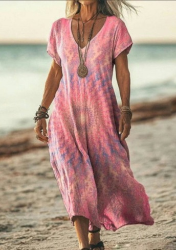 Woman wearing a pink tie-dye dress on a beach