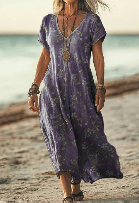 Woman wearing a purple floral dress on a beach