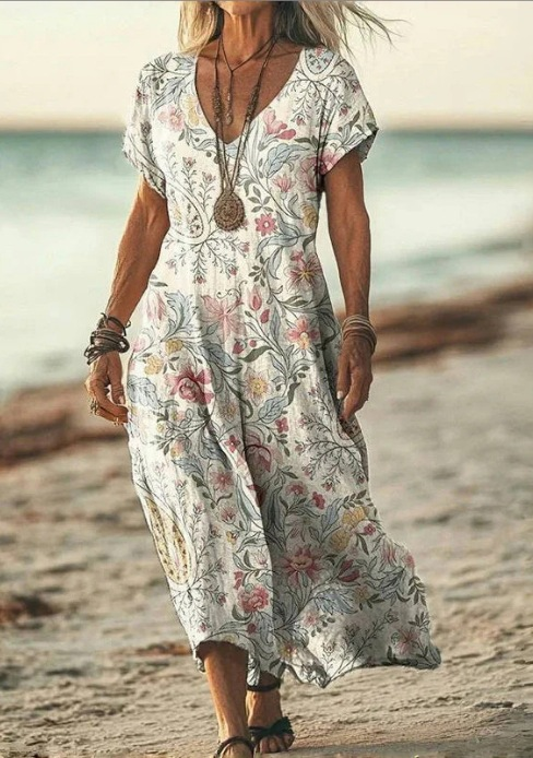 Woman in a floral dress standing on a beach