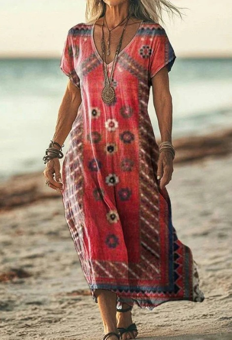 Woman wearing a red patterned dress on a beach