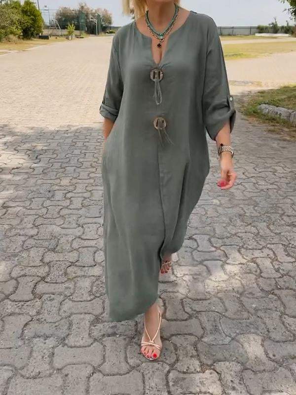 Person wearing a long green dress on a paved path outdoors