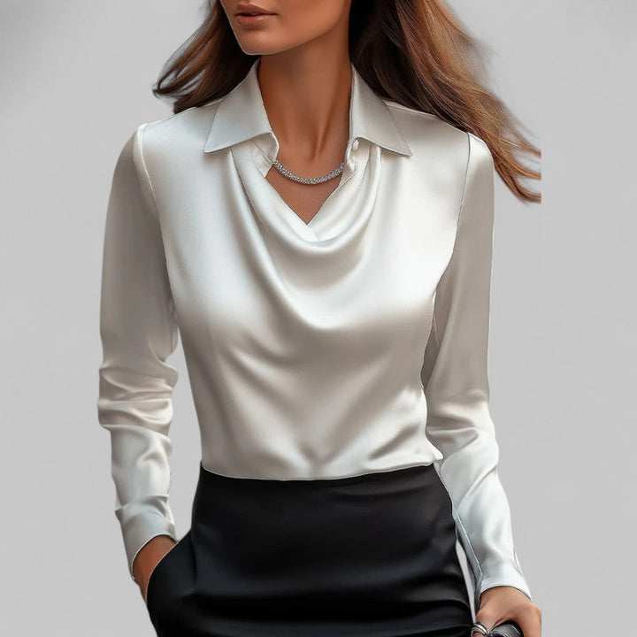 White blouse with a V-neck and long sleeves worn by a person on a plain background