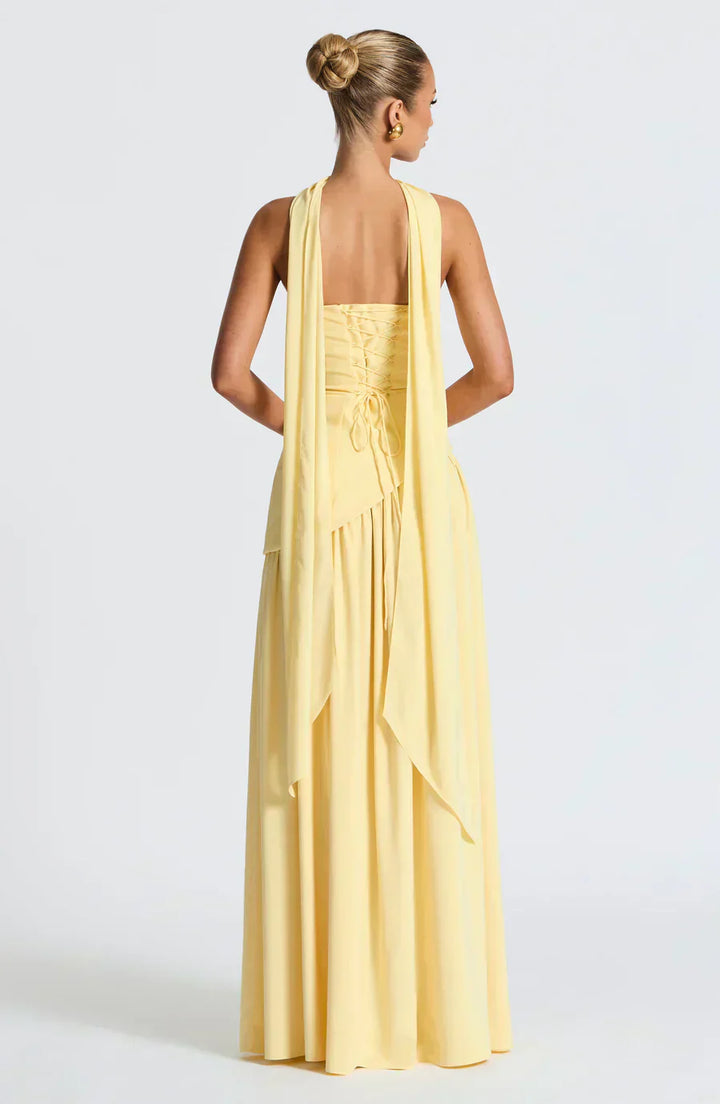 Woman wearing a long yellow dress with a white background