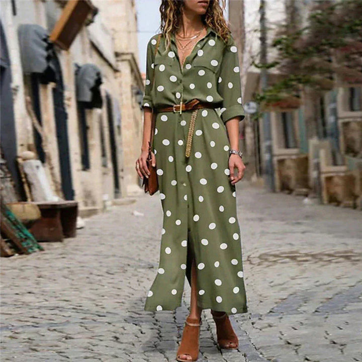 Woman wearing a green polka dot dress on a street.