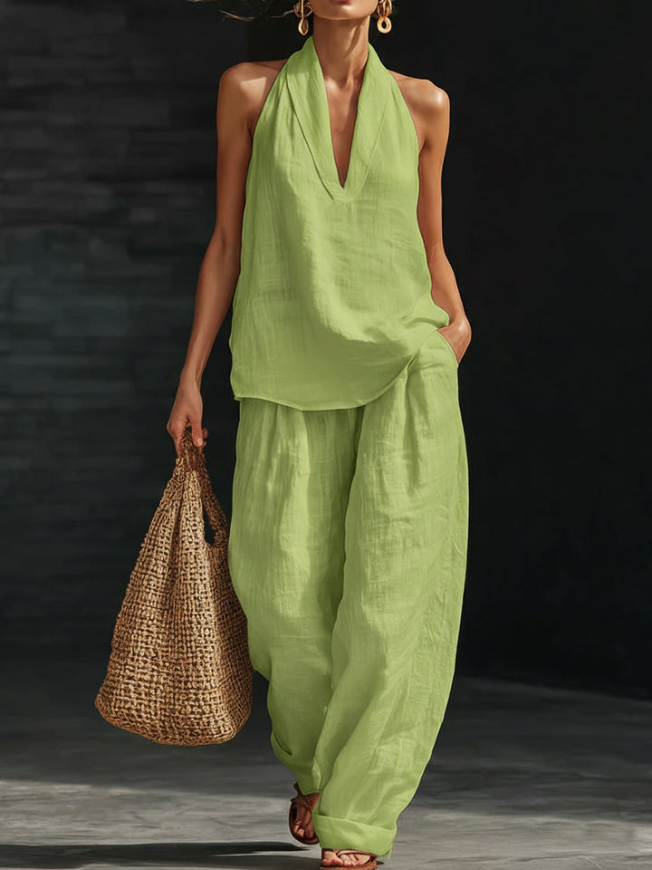 Woman wearing a green outfit holding a woven bag on a dark background