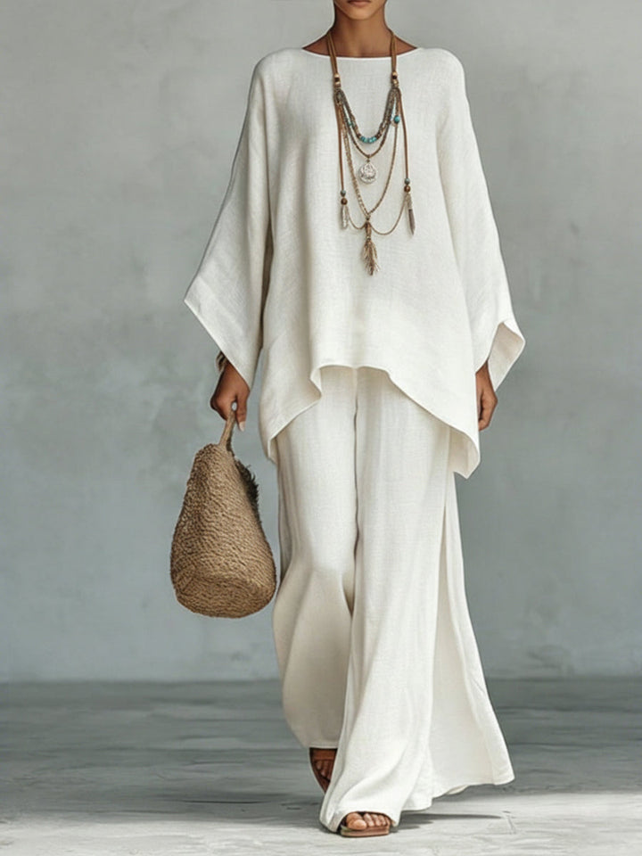 Person wearing a white outfit with a textured bag against a gray background