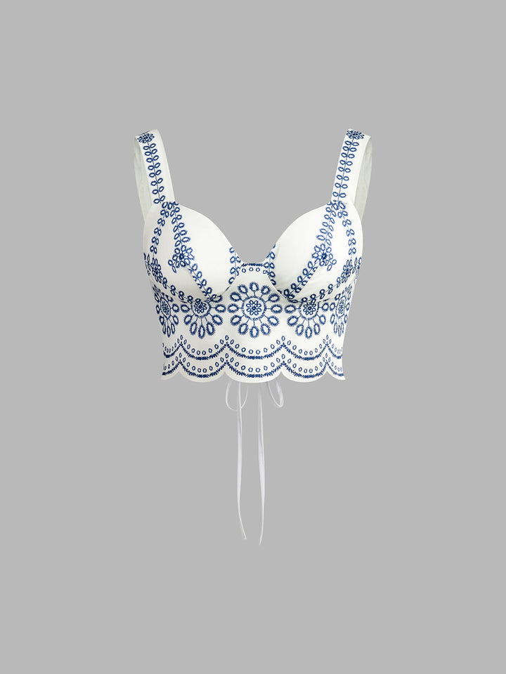 White bra with blue lace detailing on a gray background