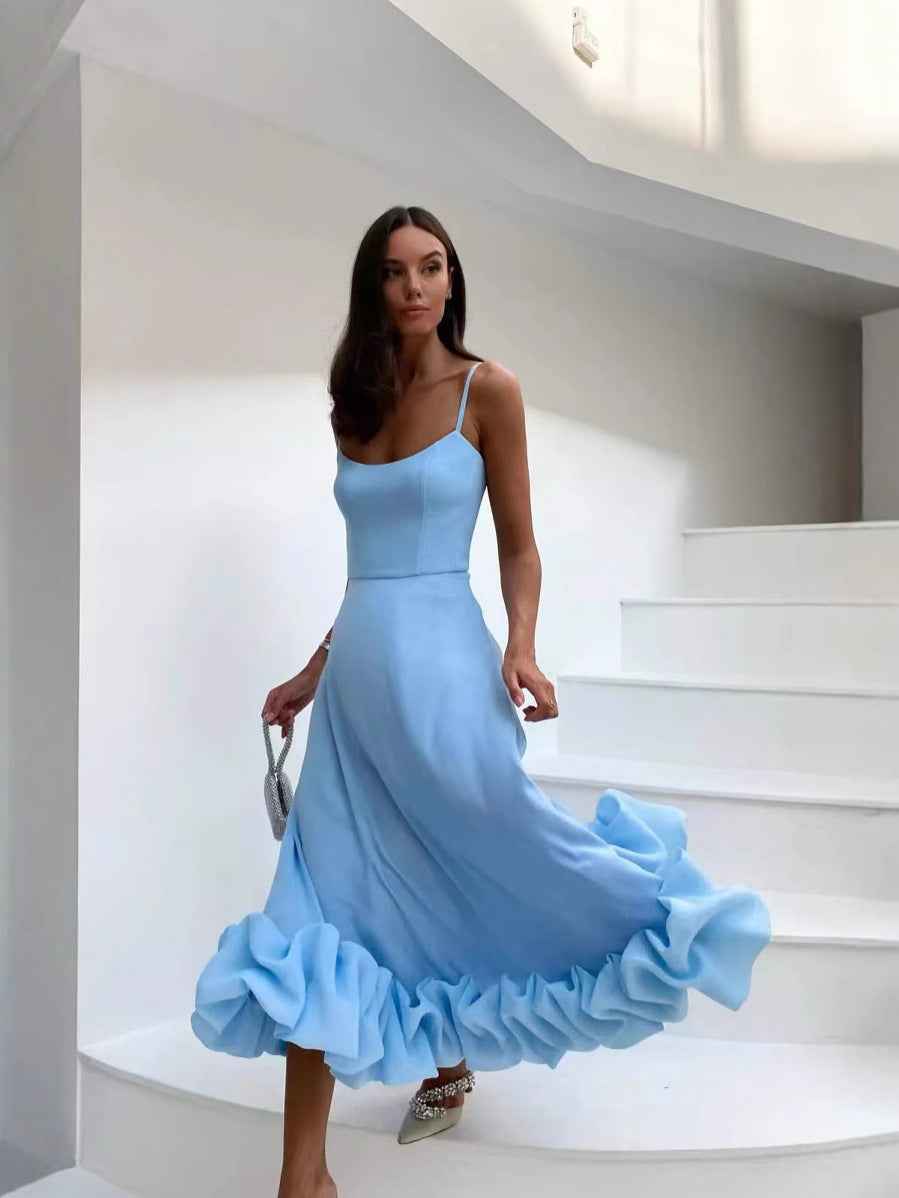 Woman in a light blue dress standing on a white staircase.