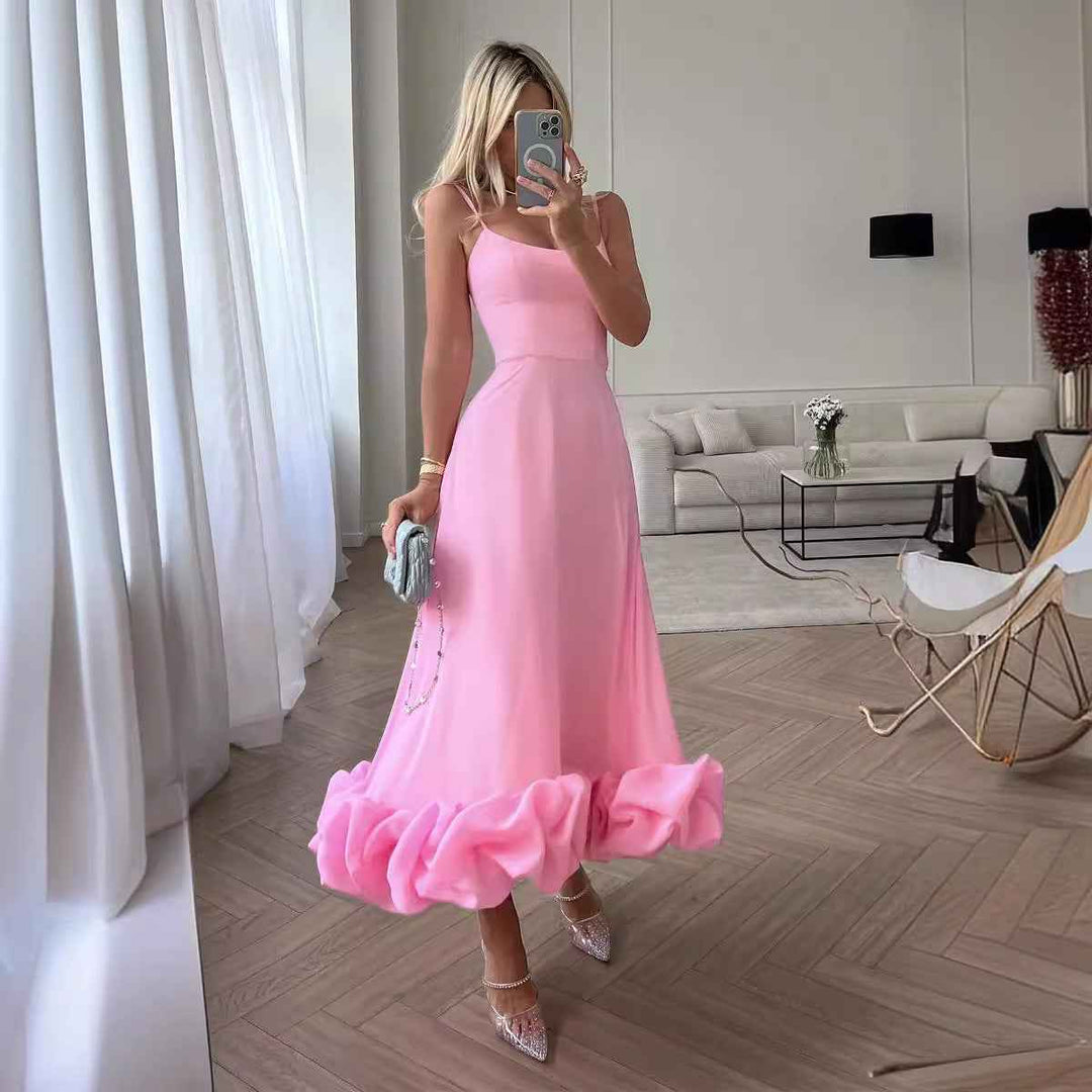 Woman in a pink dress taking a mirror selfie in a modern living room.
