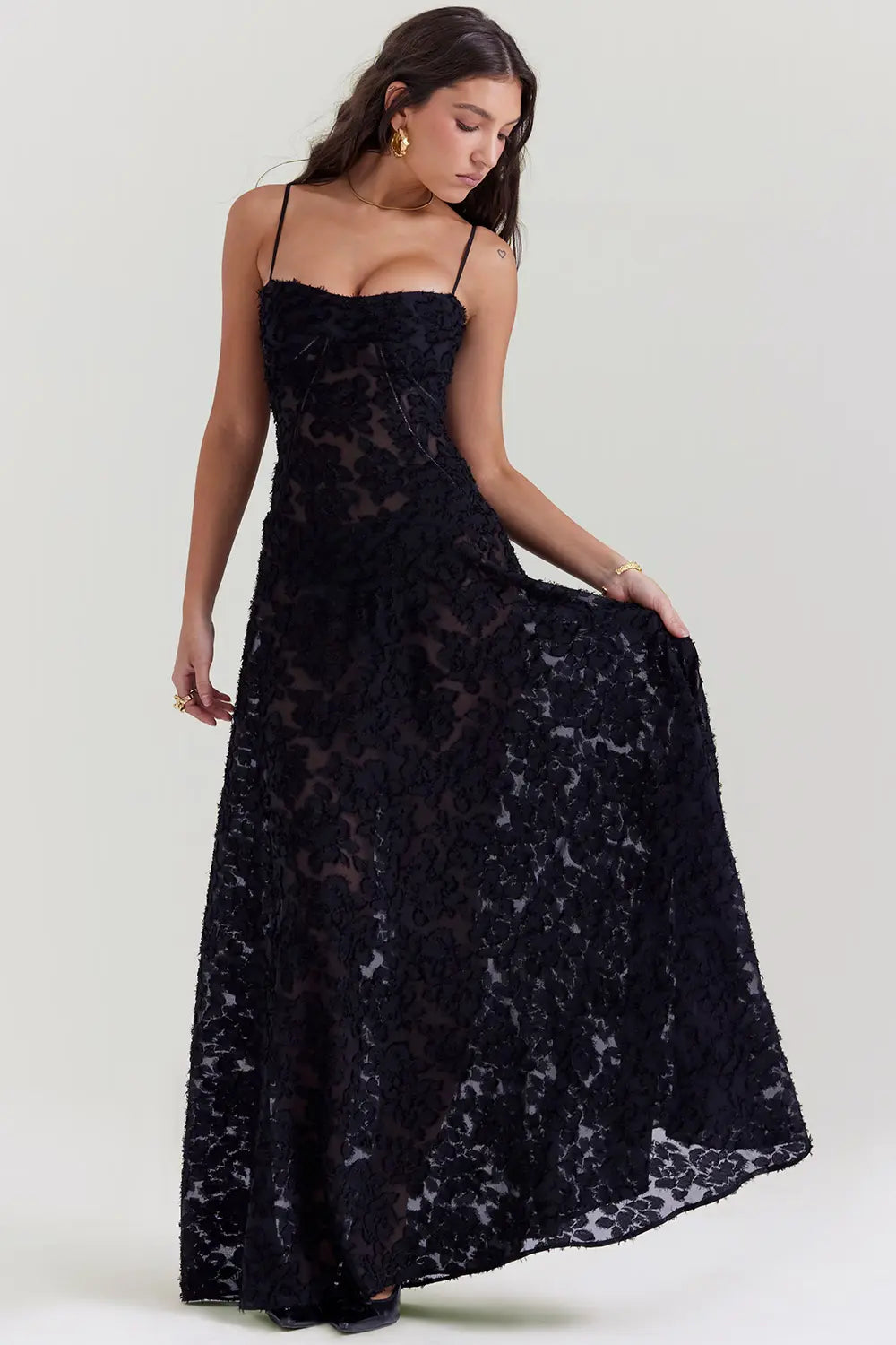 Woman wearing a black lace dress on a white background