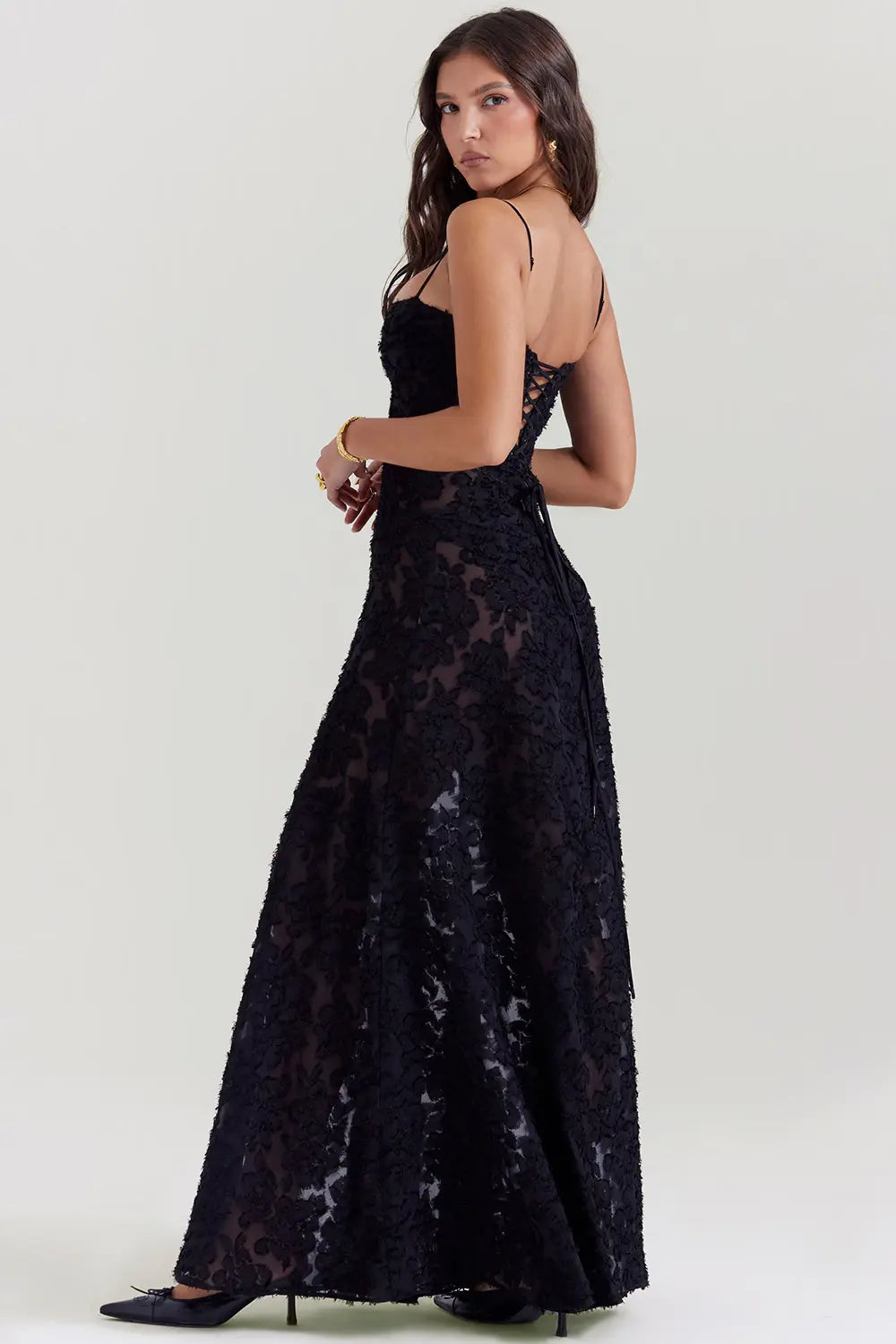 Woman wearing a black lace dress on a white background