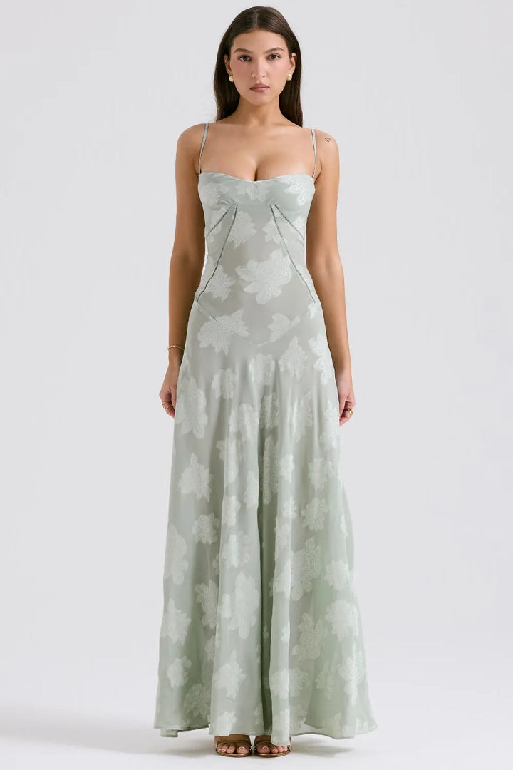 Woman wearing a light green floral dress on a white background