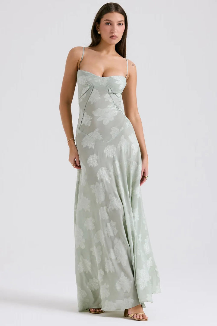 Woman wearing a light green floral dress on a white background