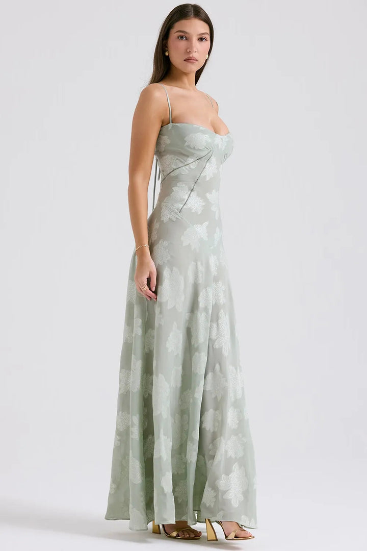 Woman wearing a strapless, long, light green dress with a subtle pattern on a white background