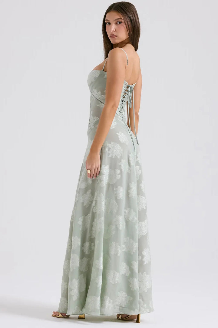 Woman wearing a light green floral dress on a white background
