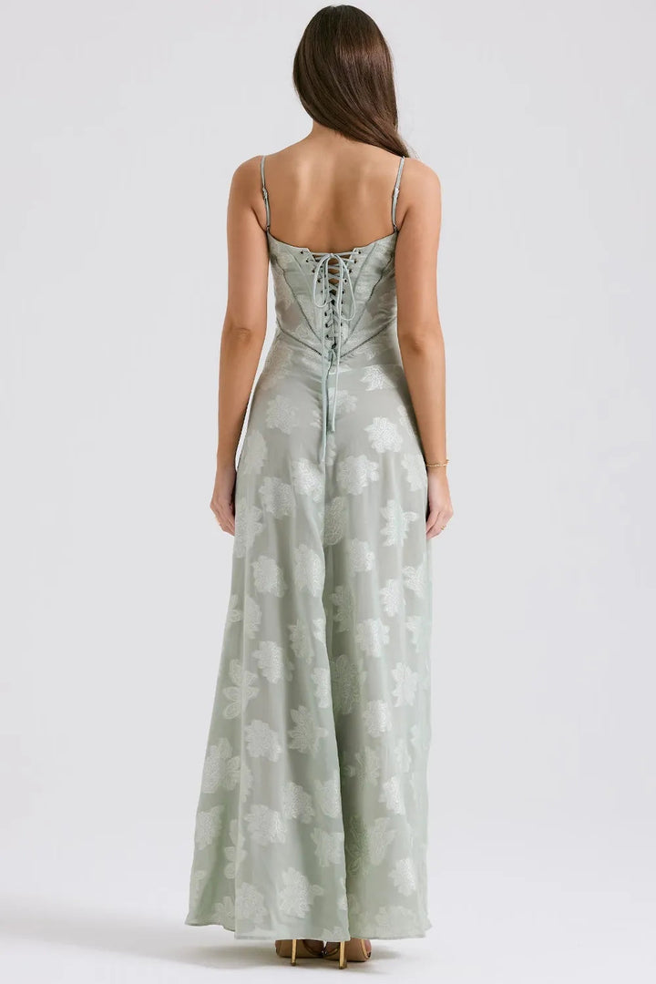 Woman wearing a light green floral dress on a white background