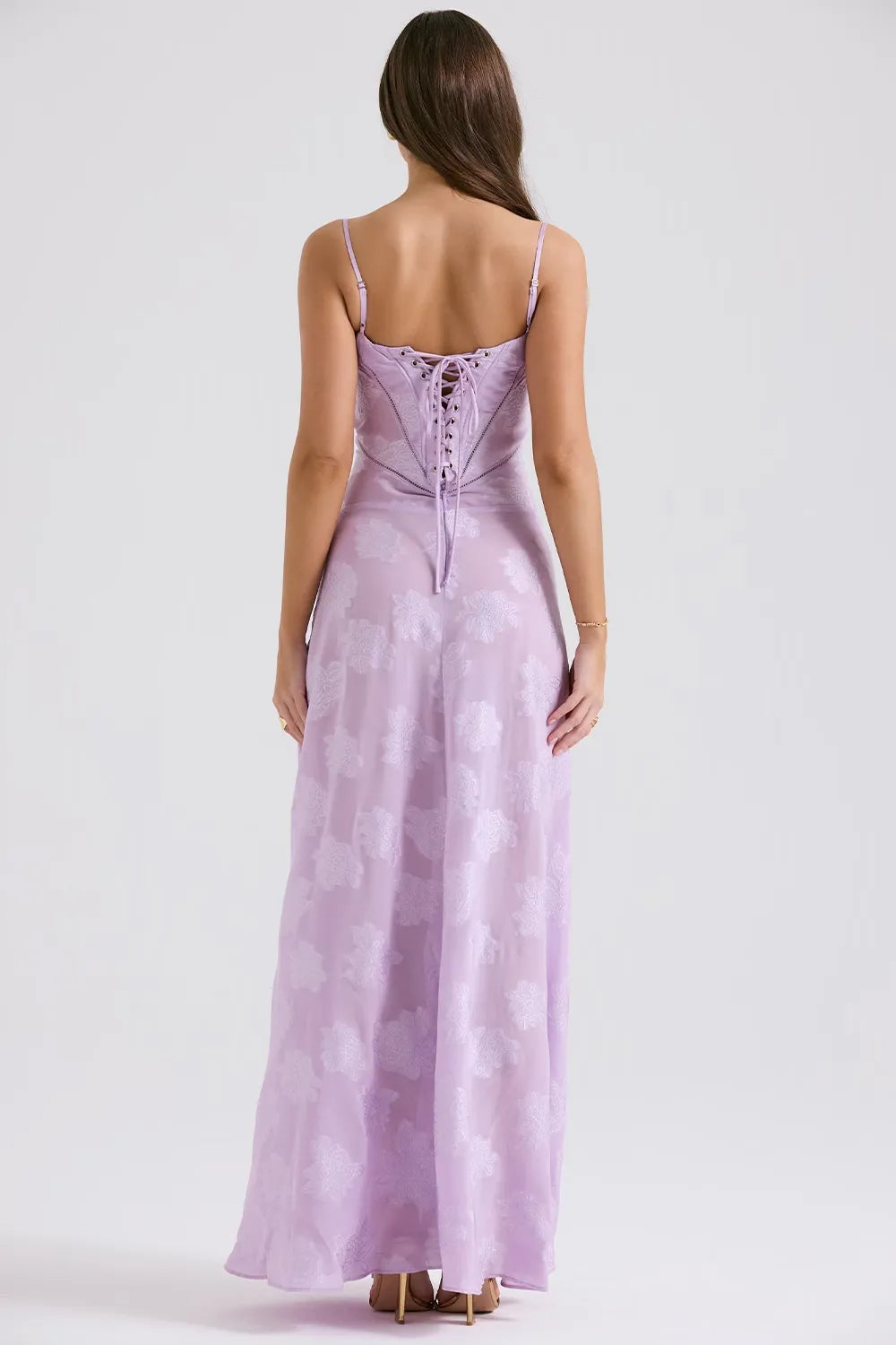 Woman wearing a long lavender dress with a white background