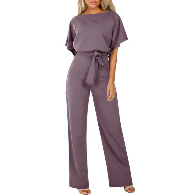 Purple jumpsuit worn by a model on a white background