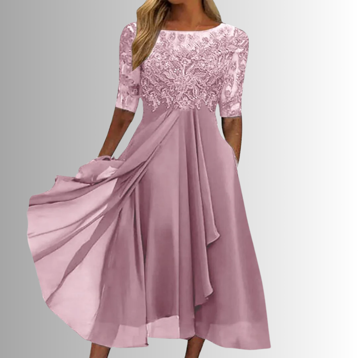 Pink lace dress with flowing fabric on a gray background