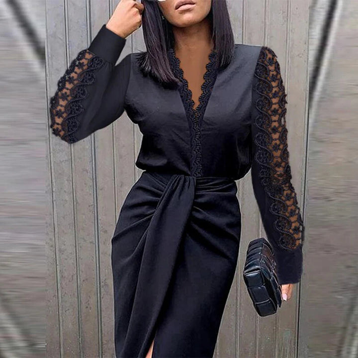 Woman wearing a black dress with lace sleeves against a gray background