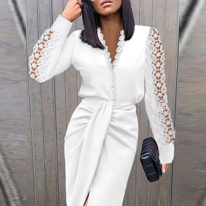 Woman wearing a white dress with lace sleeves against a gray background