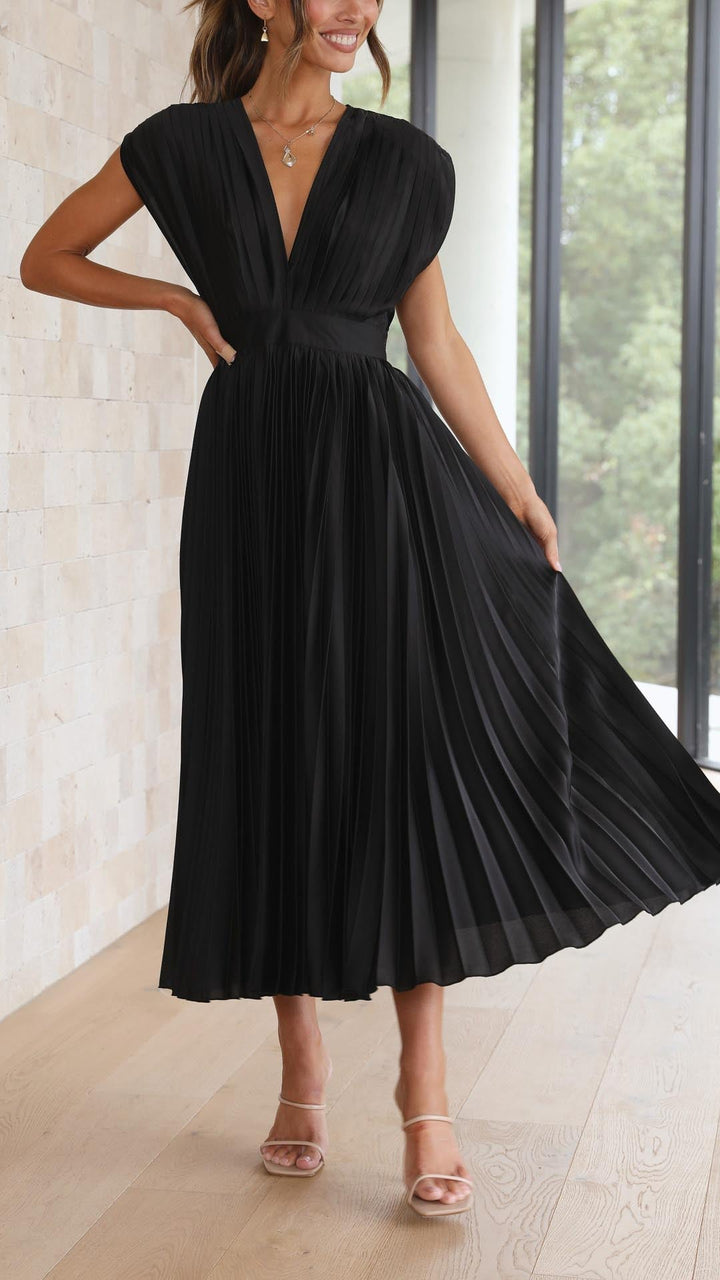 Woman wearing a black pleated dress in an indoor setting
