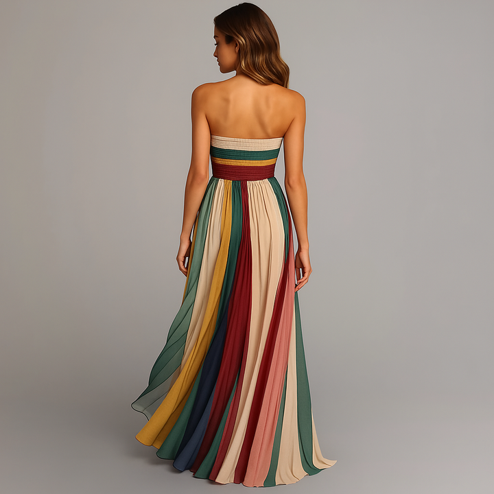 Woman wearing a strapless, long, multicolored dress on a gray background